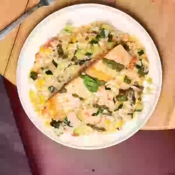 Grilled salmon over creamy risotto with seasonal vegetables